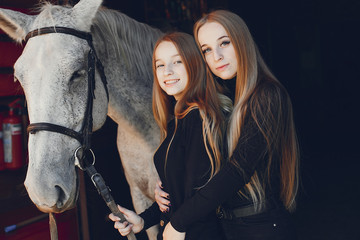 Girls with a horse. Women in a ranch. Blonde in a black sweater