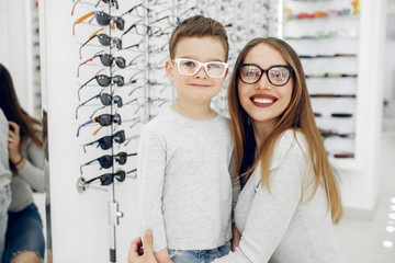 Mother with cute son. Family buy glasses