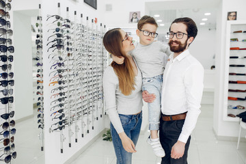 Mother with cute son. Family buy glasses. Father in a white shirt