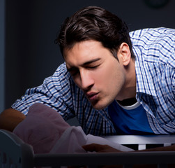 Happy dad looking after newborn baby at night