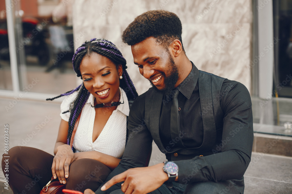 Wall mural A stylish and beautiful dark-skinned couple in a city