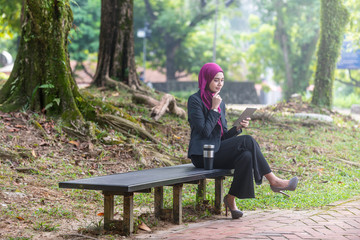 Muslim Businesswon on her table during a coffee break. Outdoor setting at a park.