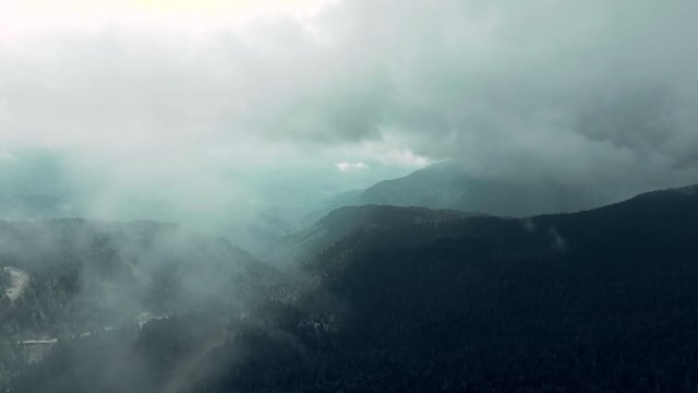 Aerial 4k view. Flying through the clouds above mountain tops. High peaks wonderful morning sunrise natural Landscape.