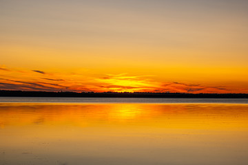 Fototapeta na wymiar sunset at Glenwood Beach Park with great light, sun, trees, and lake