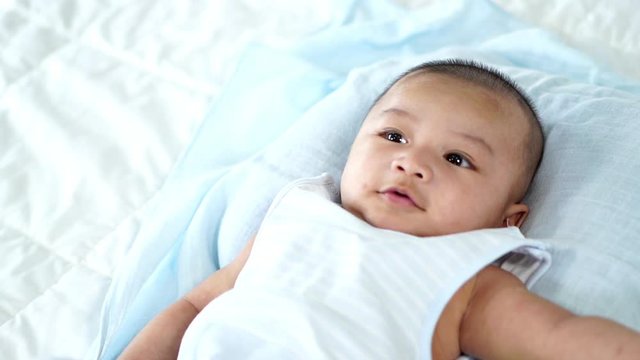 slow-motion of little cheerful baby on a bed