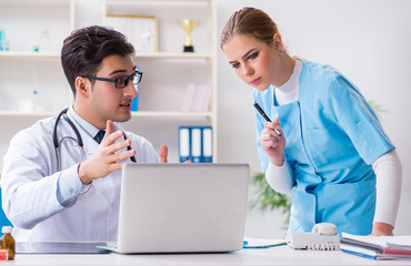 Male and female doctor having discussion in hospital