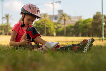 six year old child putting on her in-line skates