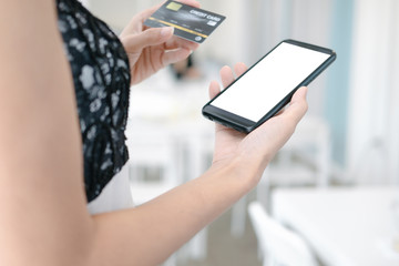 Mockup image of Beautiful woman holding credit card shopping online with smartphone on online websites, mockup concept