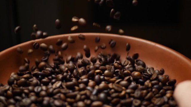 Farmer Throws Up Roasted Brown Coffee Beans on Black Background