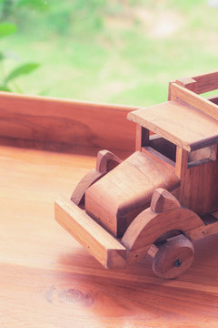 Picture of classic wood retro truck toy wtih beautiful blur greenery background with copy space. Simple and minimal vintage style for wallpaper. Photo concept for education, kid, and transportation