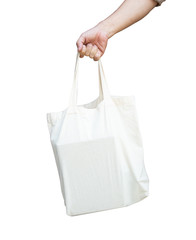 male hand is carrying a white cloth bag to help with the use of plastic bags to reduce global warming.