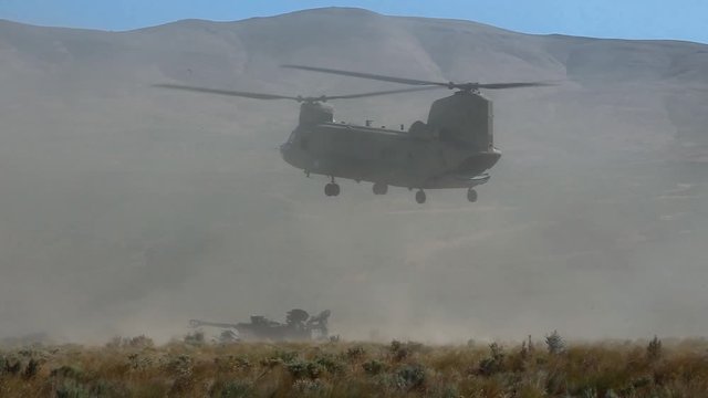 2010s - A US Army transport helicopter lands in a dry field.