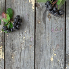 Top view bowl of berries and flowers on old wooden background. Selective focus. Space for text.