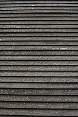 old gray brown beige wooden surface with peeling paint and horizontal lines. rough texture