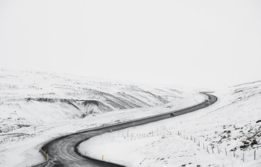 Uphill curve road with side way full of snow in winter