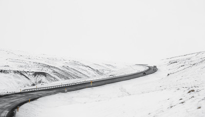 Uphill curve road with side way full of snow in winter