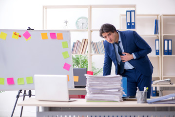 Young male employee unhappy with excessive work