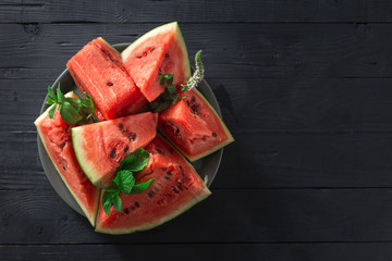 Slices of juicy ripe watermelon on a wooden background top view