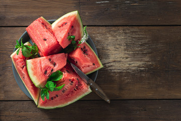 Slices of juicy ripe watermelon on a cutting board on a wooden background