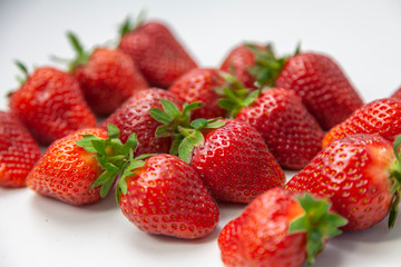 Juicy fresh strawberries close up on white background, selective focus