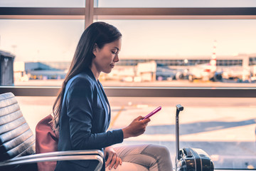 Airport phone travel Asian businesswoman using mobile smartphone in business class lounge waiting...