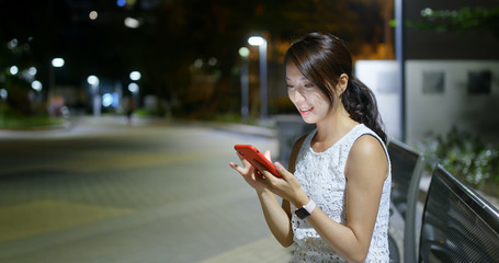 Woman use of smart phone in city at night