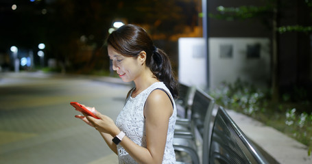 Woman use of cellphone in the city in the evening