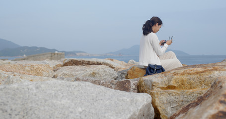 Woman control a drone at the seaside