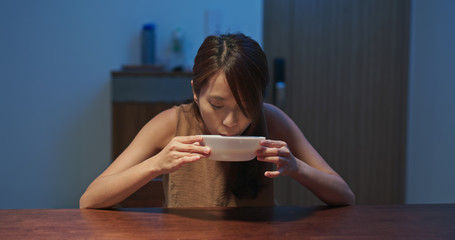 Woman drink of hot soup at home in the evening