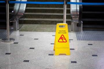selected focus on yellow plate of wet floor caution sign