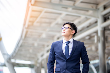 Businessman Looking Away While Standing Against Building In City