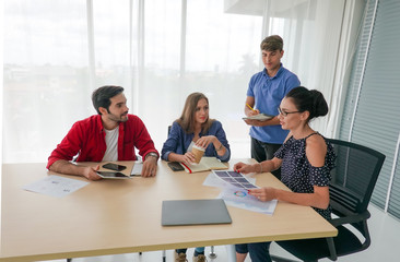 Creative business people reviewing proofs in startup office