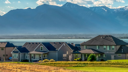 Panorama frame Residential area with scenic view of lake and mountain under cloudy blue sky