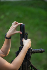 Naklejka premium girl holds the barrel of an assault rifle