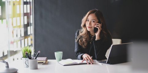 Attractive Asian businesswoman smiling and looking at the camera