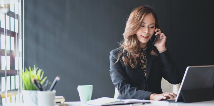 Attractive Asian Businesswoman Speaking On The Phone With Customer