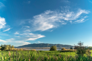 Nature scenery with a mountain towering over a calm lake viewed on a sunny day