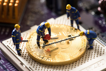 miniature worker cutting bitcoin , halving concept