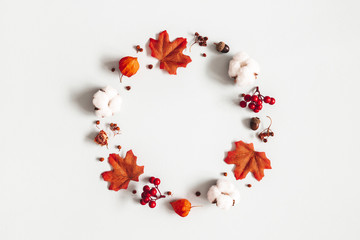 Autumn composition. Wreath made of flowers, maple leaves on gray background. Autumn, fall, thanksgiving day concept. Flat lay, top view, copy space