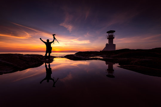 Silhouette Photographer With Lighthouse at sunset - Powered by Adobe