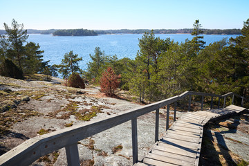 Wooden stairs leading down from the rocks towards the sea. sunny spring day at Finnish archipelago in the Kemi&ouml; Island, Finland.