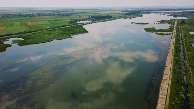 Aerial view of blue river whit reflections on a sunny summer day. Drone flight over the River Olt, Romania.