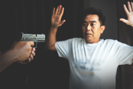 Armed robber using the gun to robbery the money with safe background.