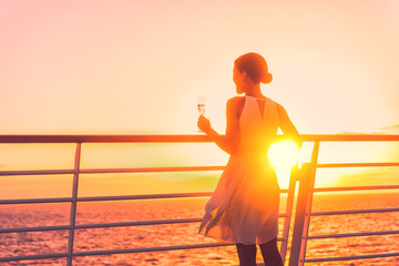Luxury cruise ship travel elegant woman drinking glass of champagne enjoying watching sunset from...