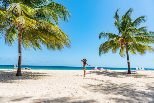 Caribbean beach travel at Barbados. Tourist woman on vacation in . tropical holidays. Dover beach, cruise travel destination. Girl walking with sun hat and bikini relaxing in water.