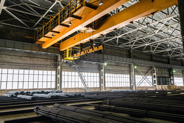 Yellow overhead crane in engineering plant shop. Industrial metalwork production hall and...