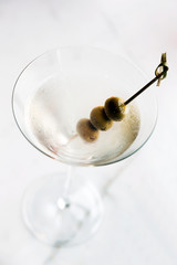 Close-up of dry martini with green olives
