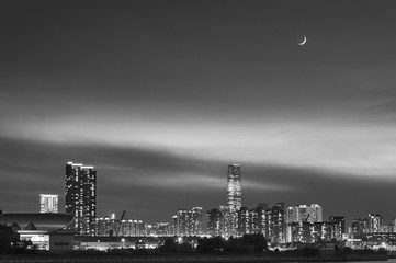 New moon over skyline of Hong Kong city at dusk