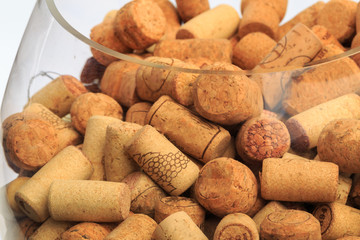 A glass bowl containing a multitude of wine corks - Image