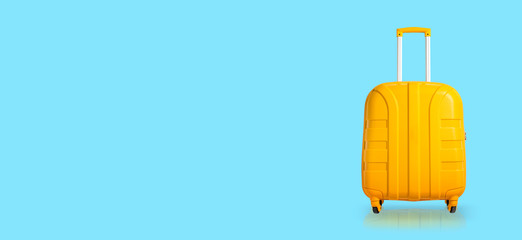 Yellow suitcase on a blue background. Banner. Travel and vacation concept